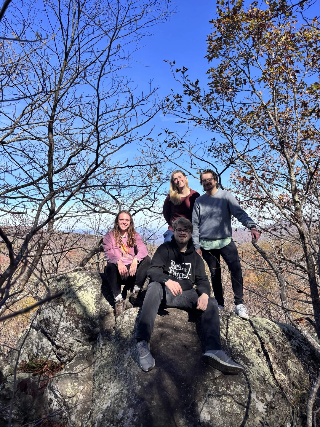 A group of people standing on a rock on the top of a mountain